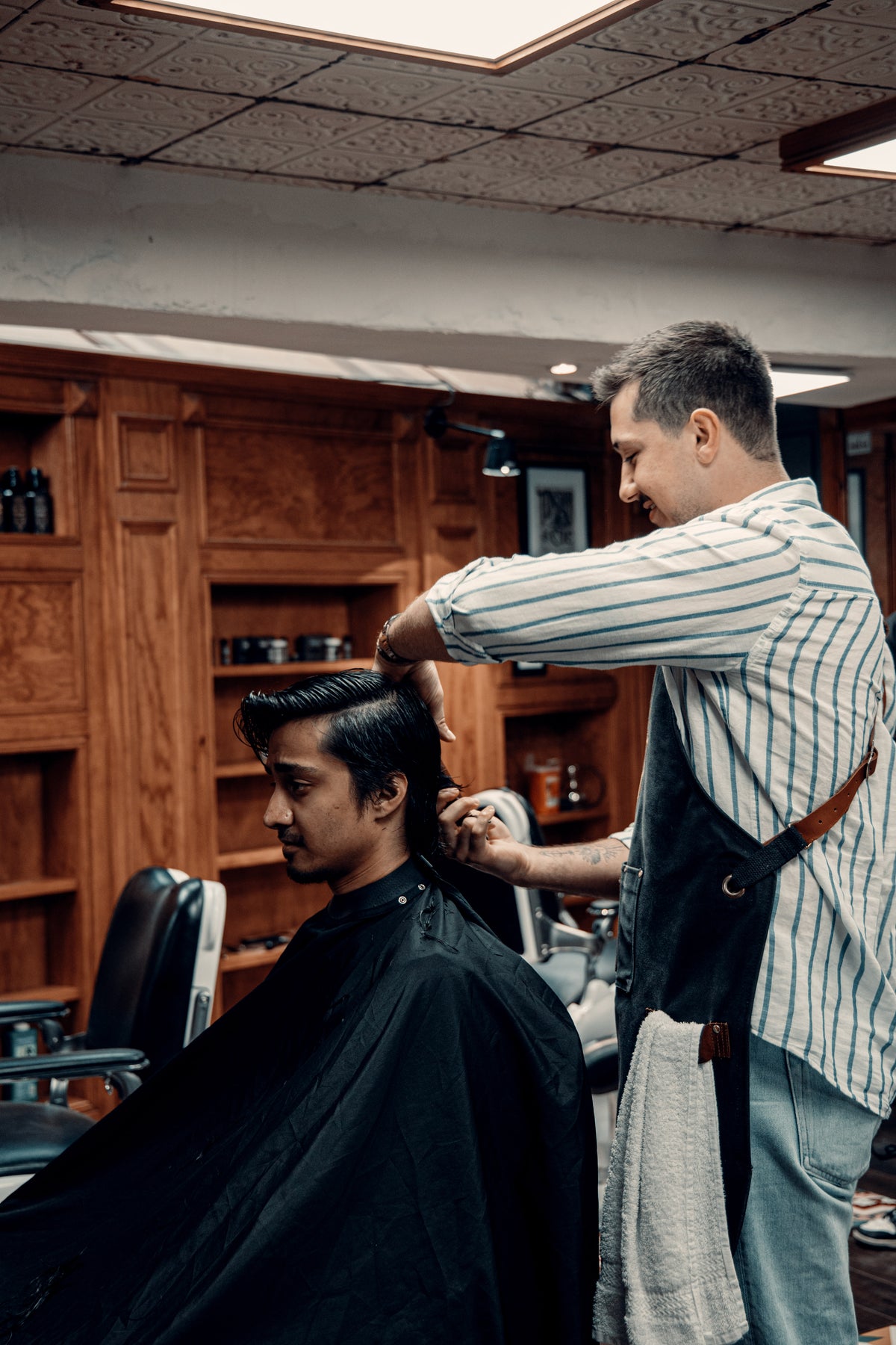 Un coiffeur Tonsor & Cie réalise une coupe homme au salon des Carmes à Toulouse