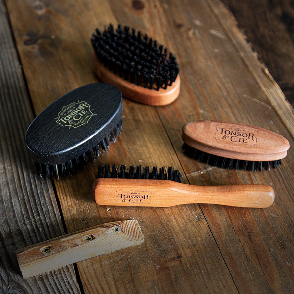 Brosses à barbe en bois et noires sur une planche de bois