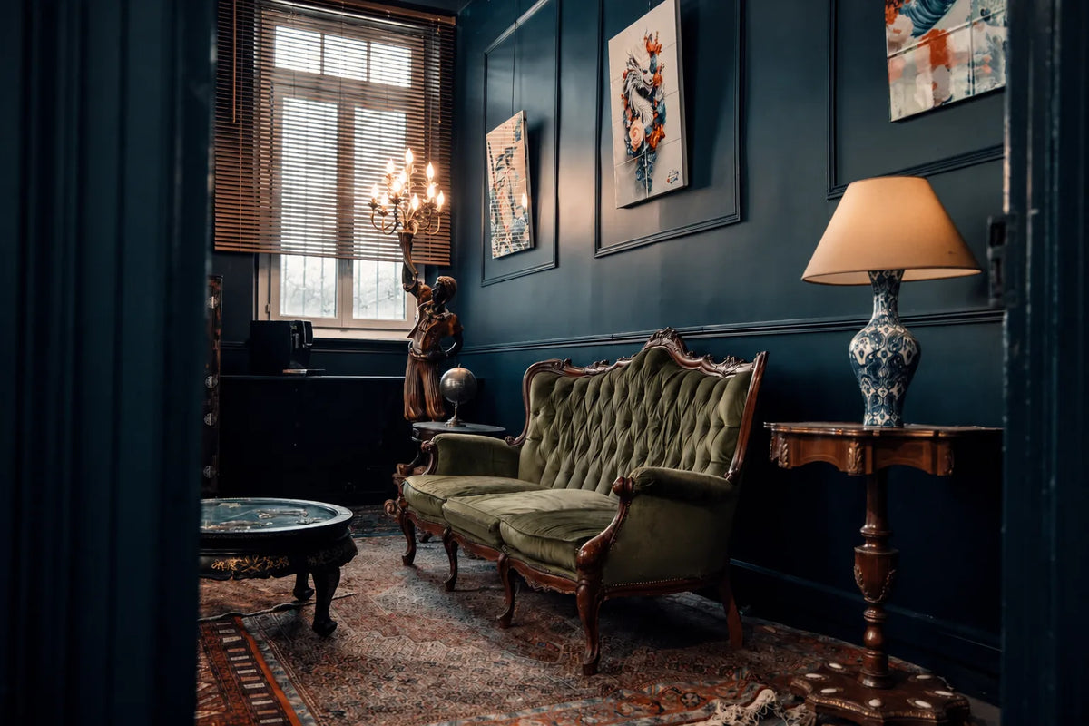 Green velvet sofa, framed artworks and lighting in Héritage’s blue lounge in Toulouse.